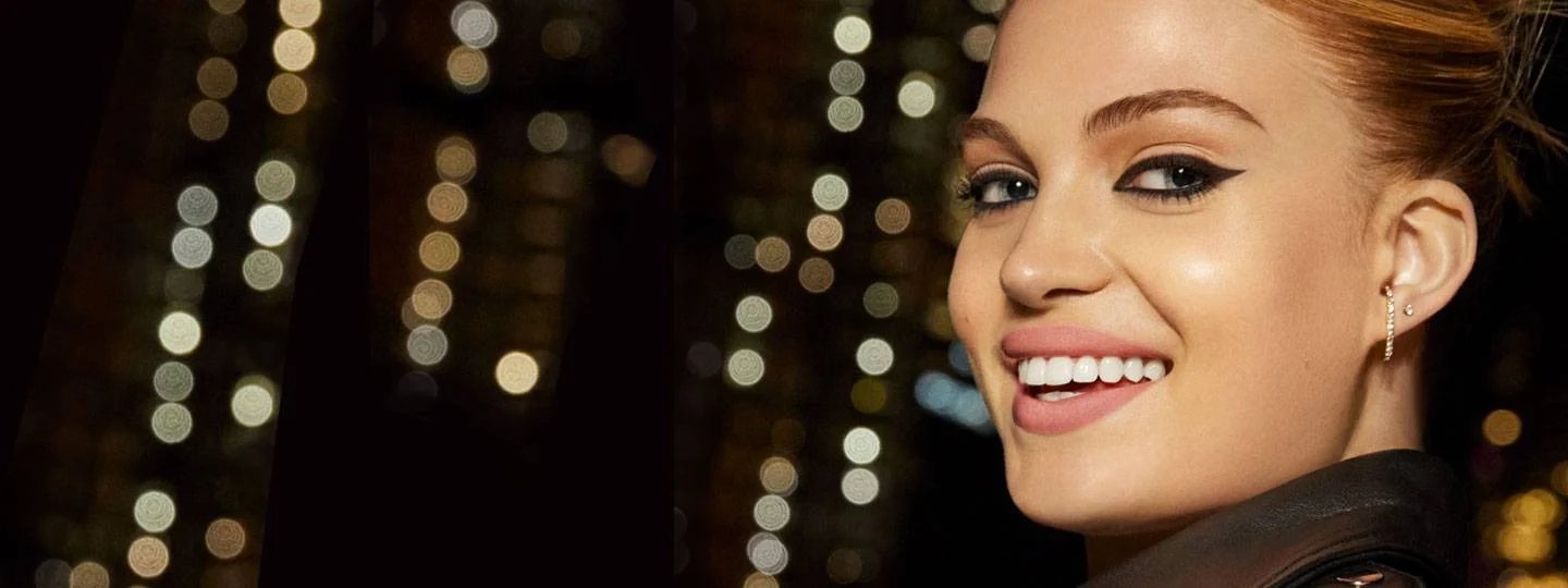 Nainen hymyilemässä kaupungit valot taustalla